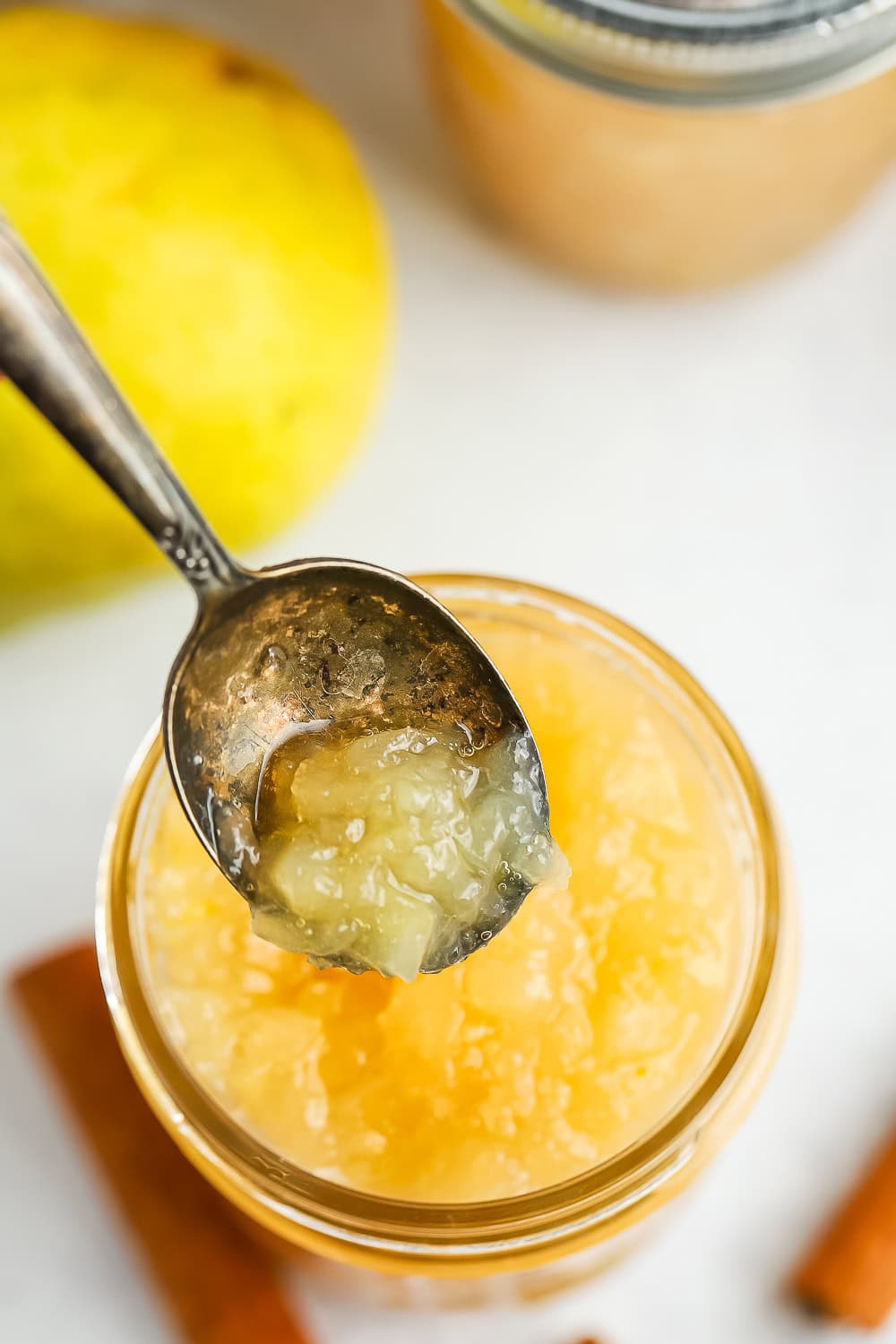 a spoonful of pear preserves above a jar.