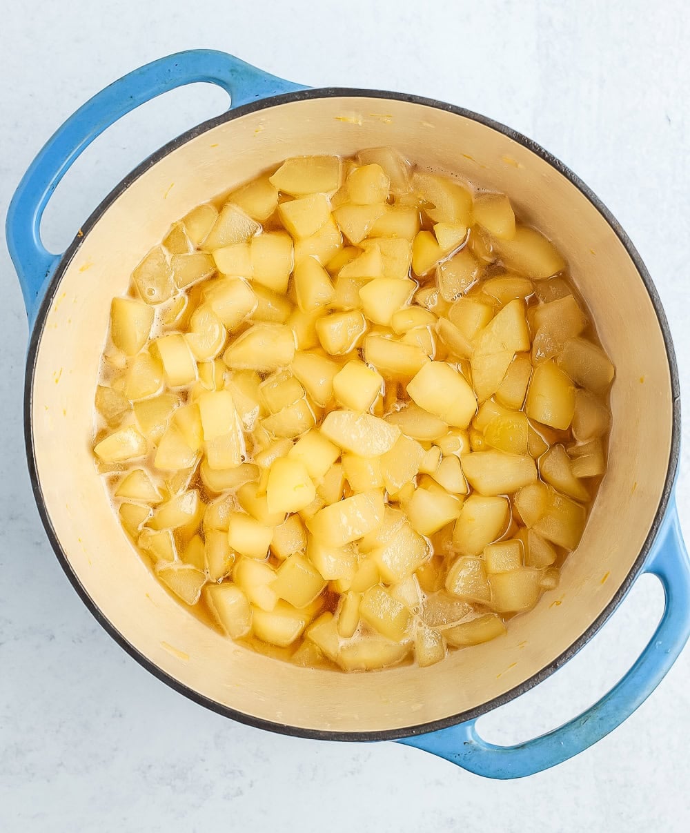 chopped fruit simmering in a blue Dutch oven.