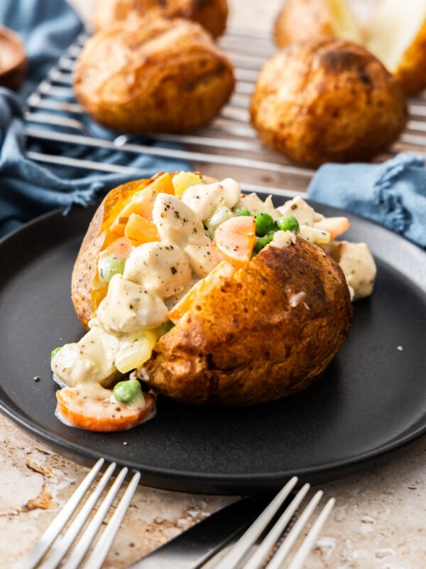 a split baked potato with chicken pot pie filling on it.
