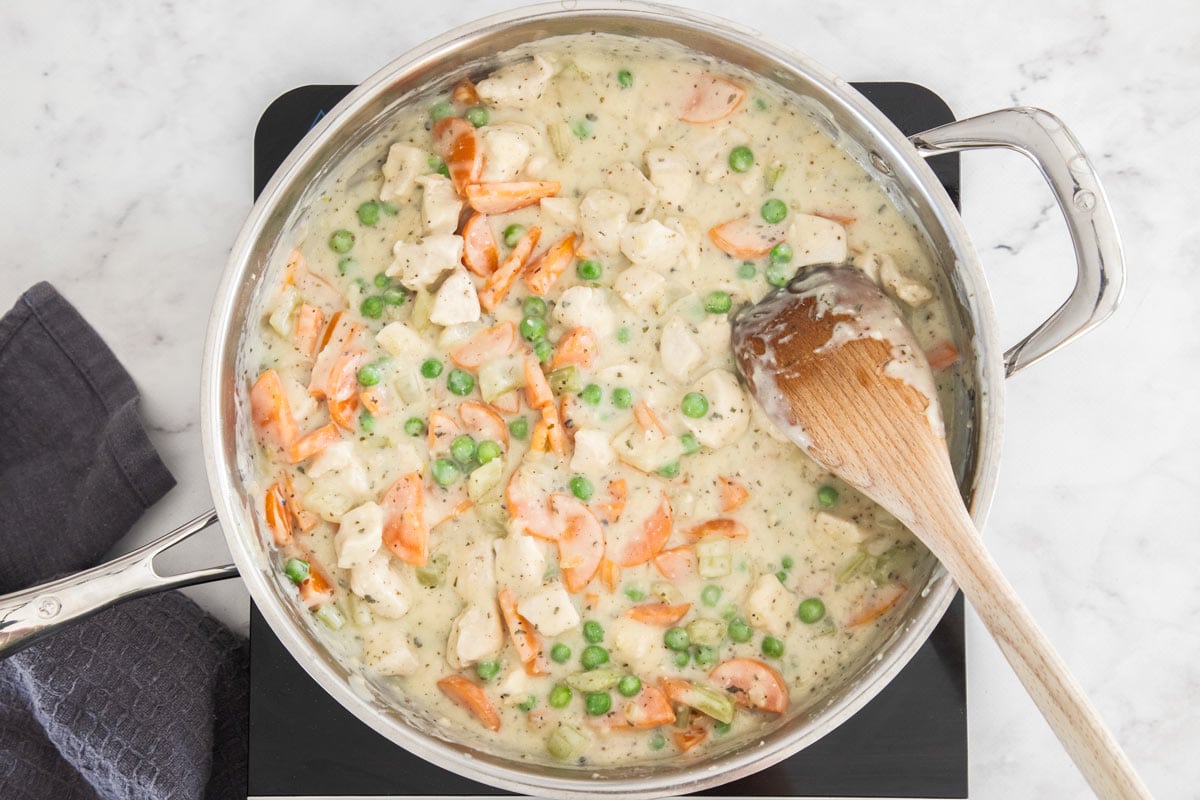 veggies and a cream sauce in a stainless skillet.