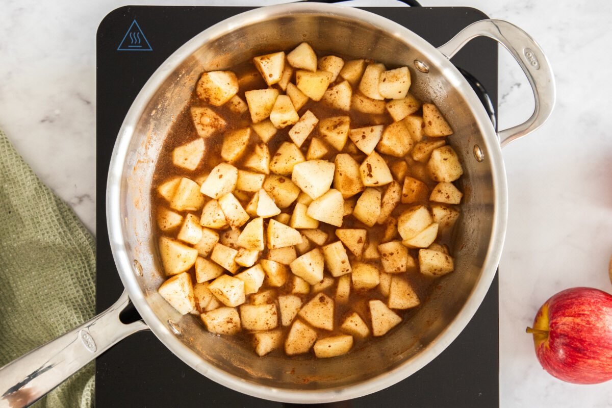 chunks of apples simmering in a skillet.