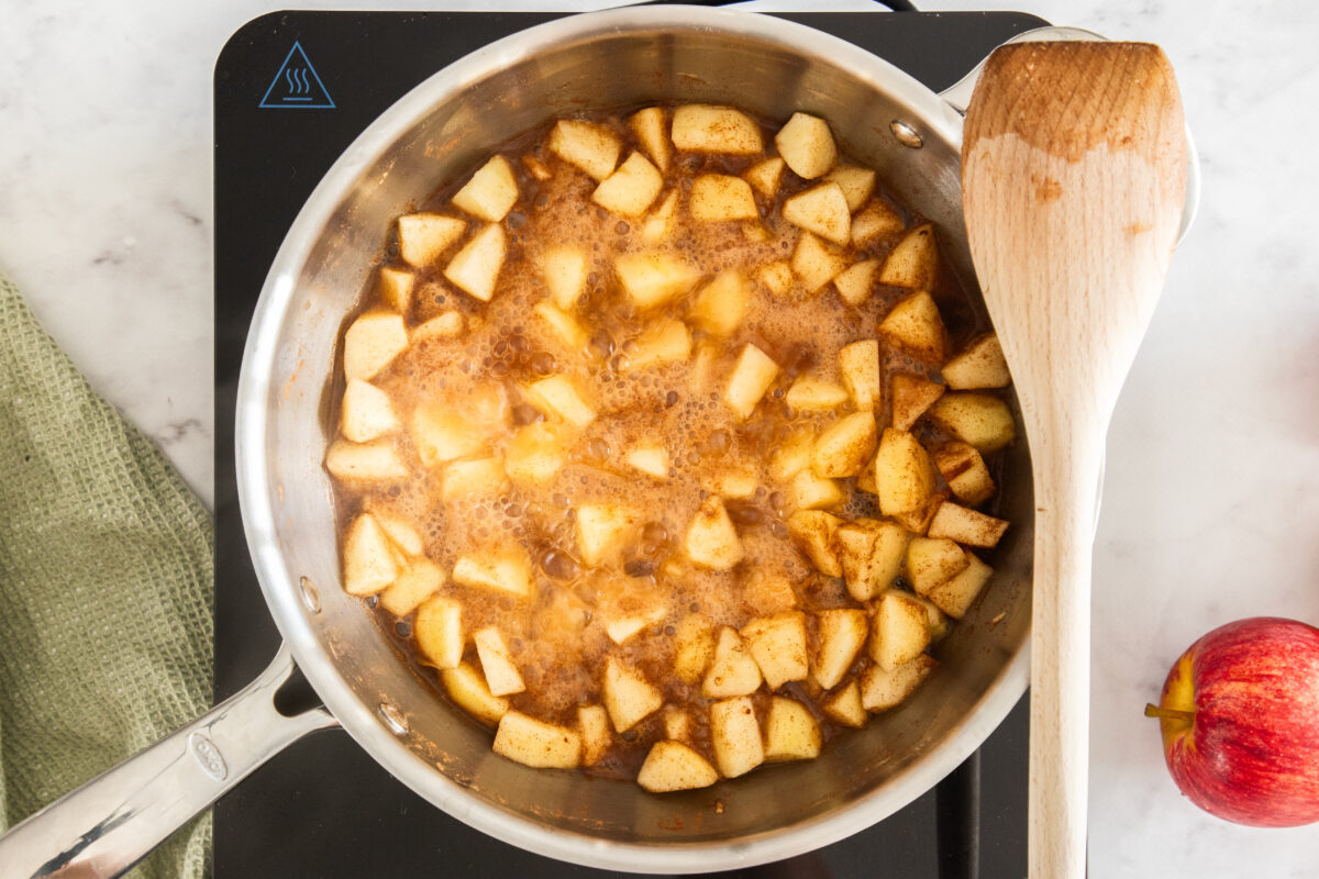 chunks of apples simmering in a skillet.