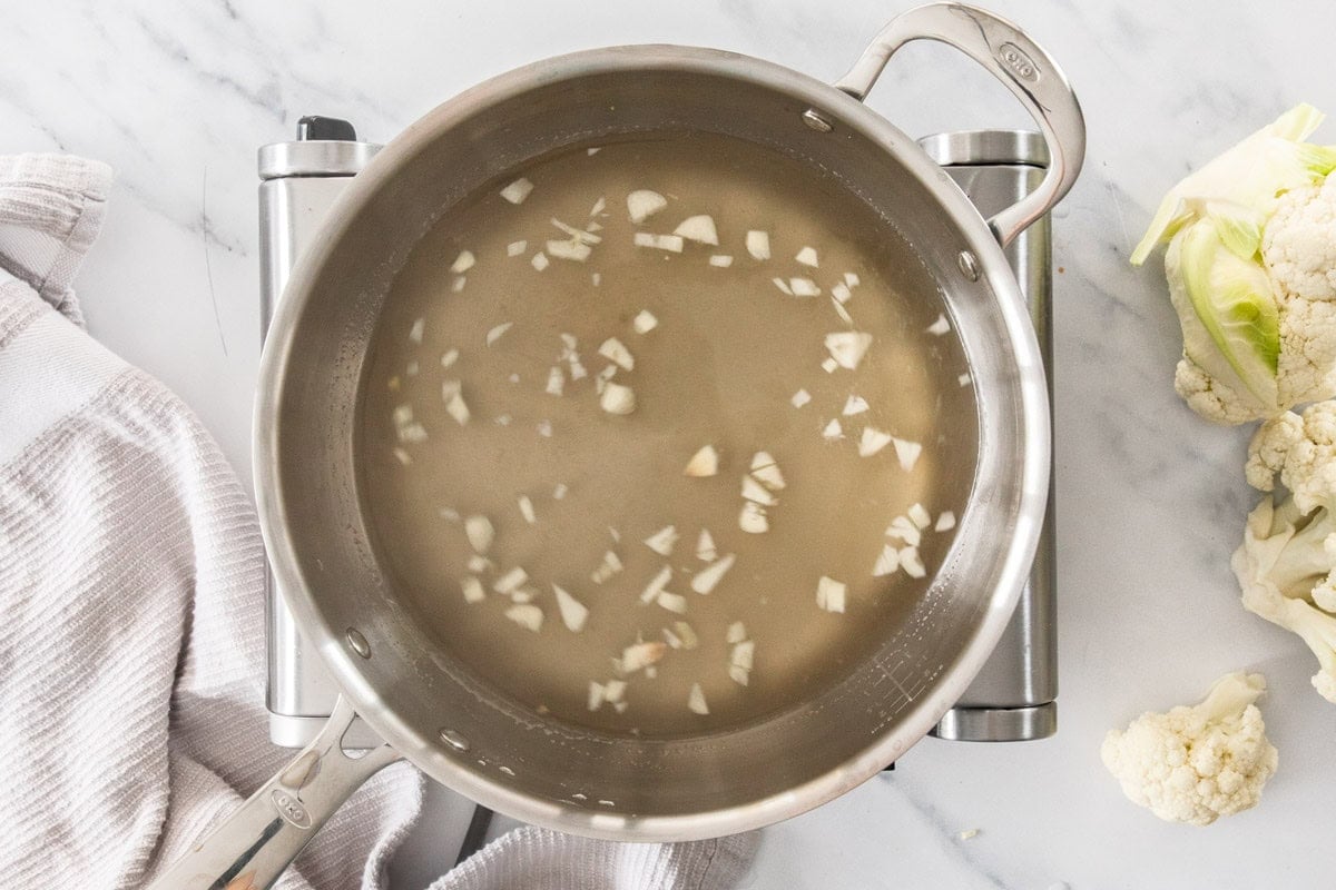garlic and liquids in a stainless pot.