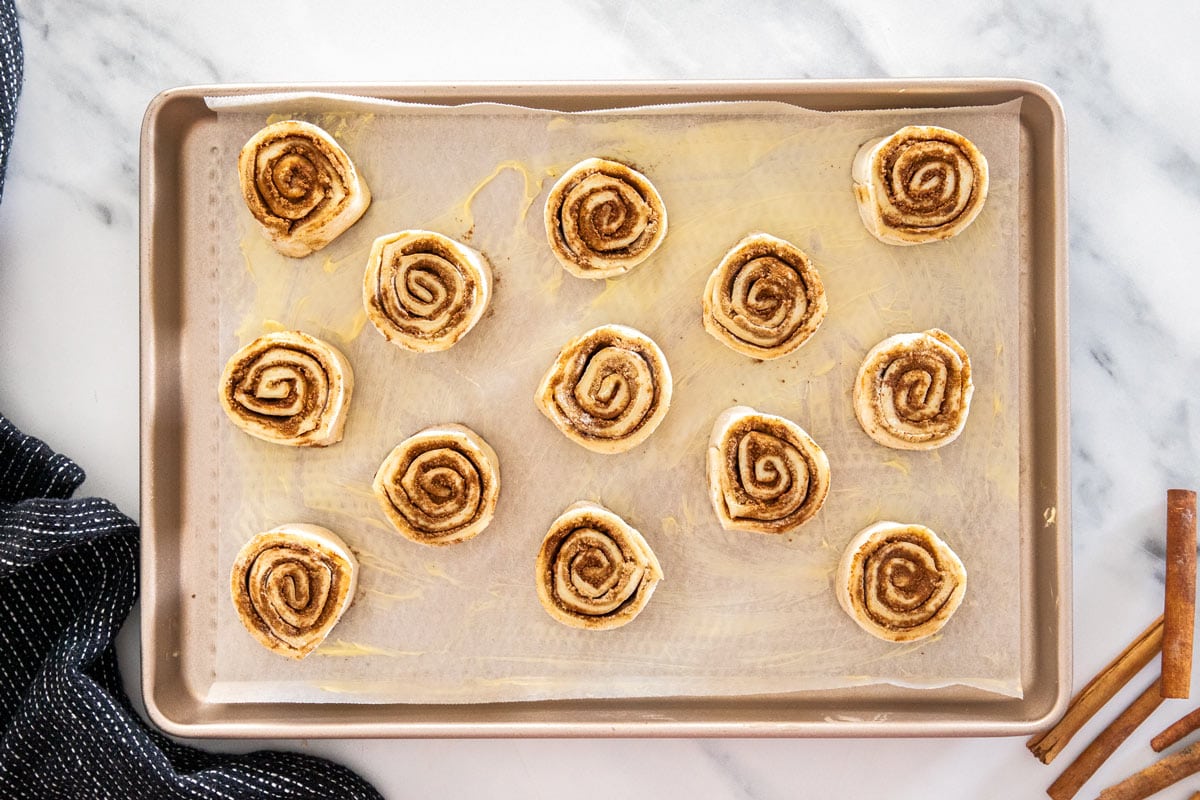 unbaked cinnamon rolls on a baking sheet.