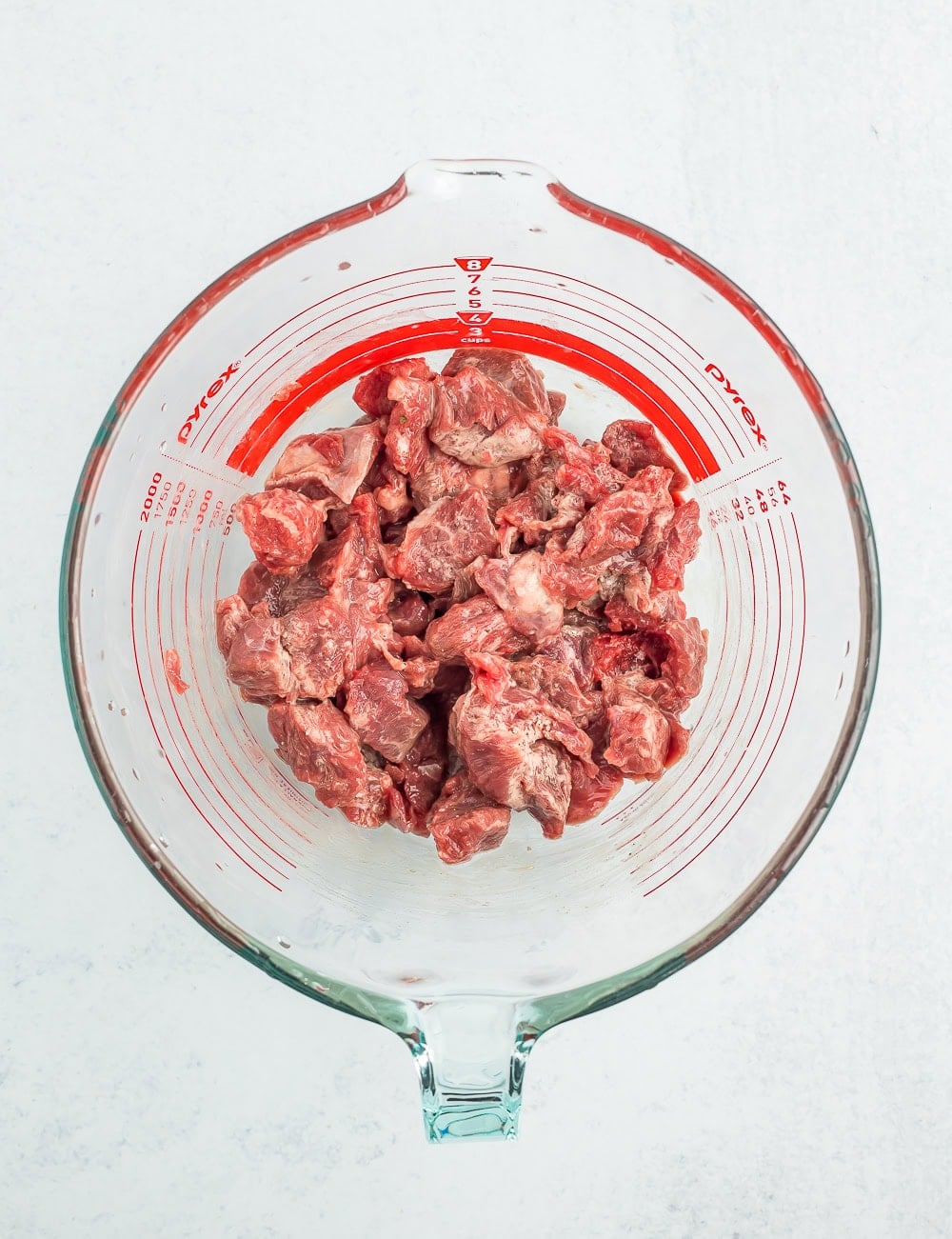pieces of stew beef in a glass mixing bowl.