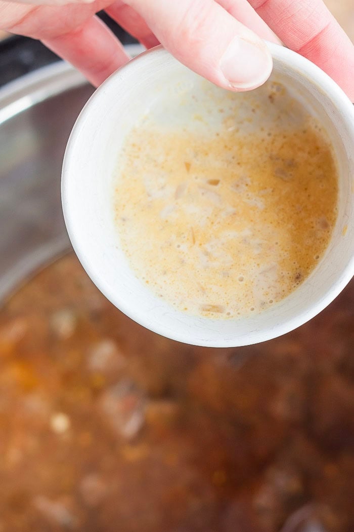 a bowl of cornstarch being poured into a pressure cooker.