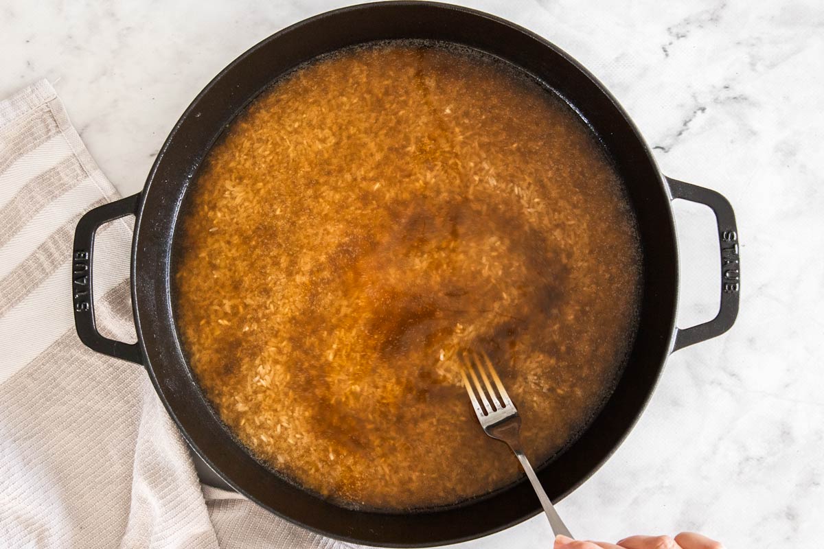 rice and broth in a black skillet.