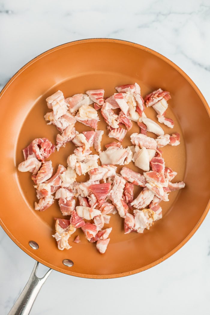 uncooked bacon in a skillet.