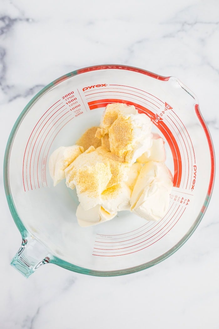 cream cheese and garlic powder in a glass bowl.
