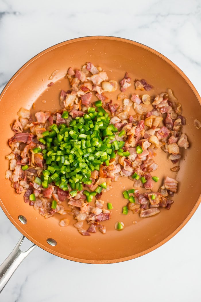 cooked bacon and chopped peppers in a skillet.
