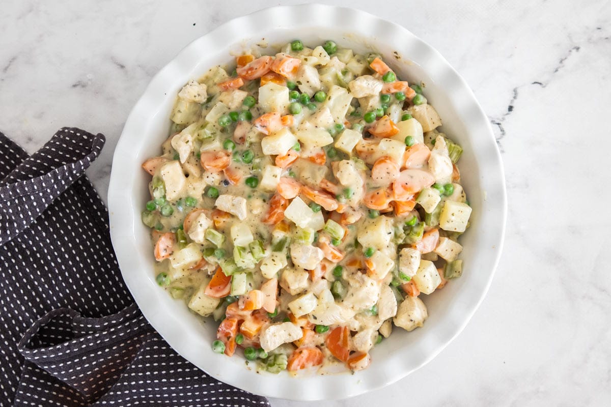 cubed chicken and vegetables in a white pie plate.
