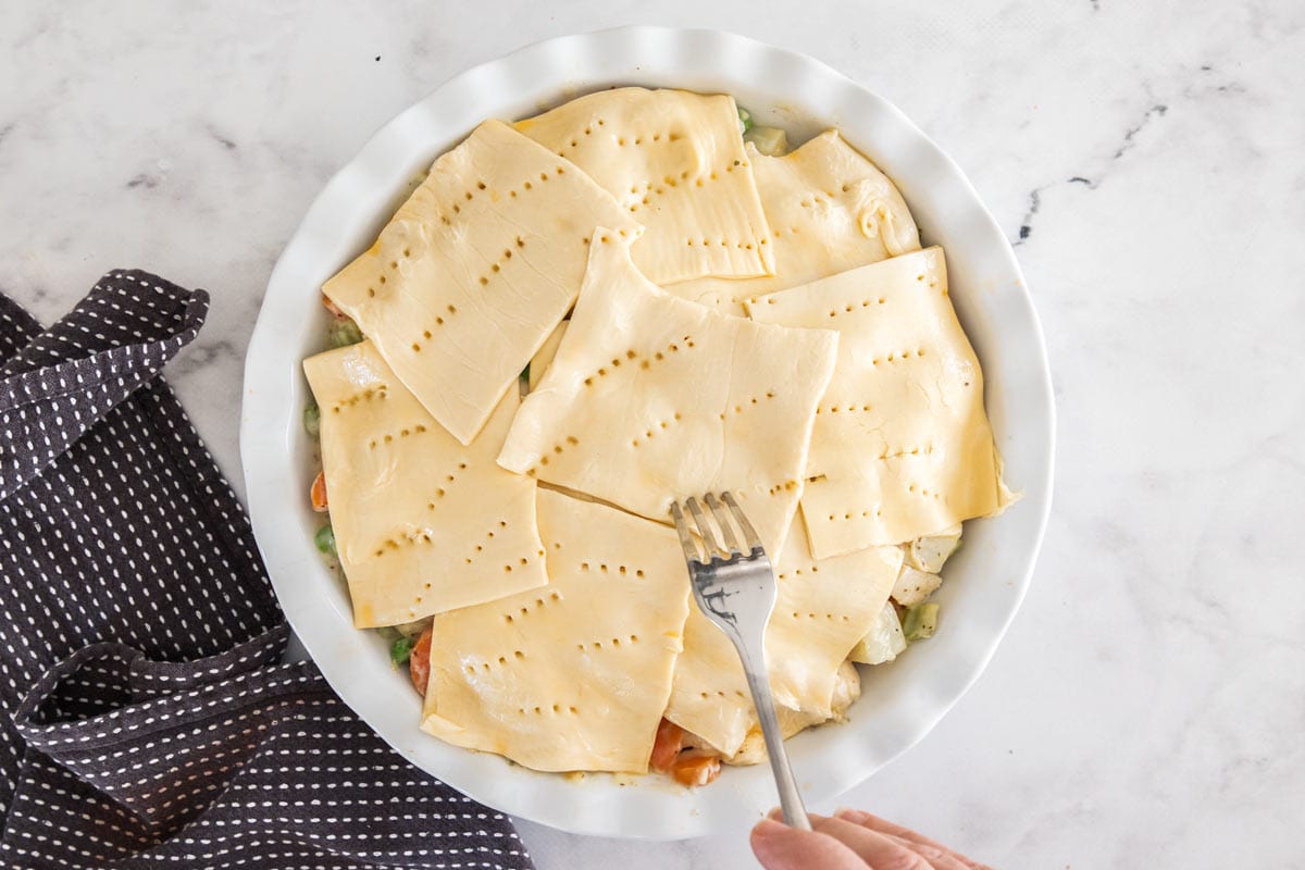pieces of uncooked puff pastry with a fork poking holes in it.