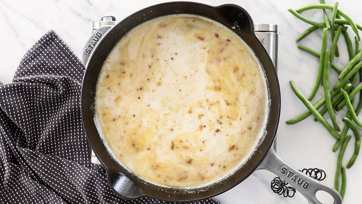a creamy sauce being made in the a skillet.
