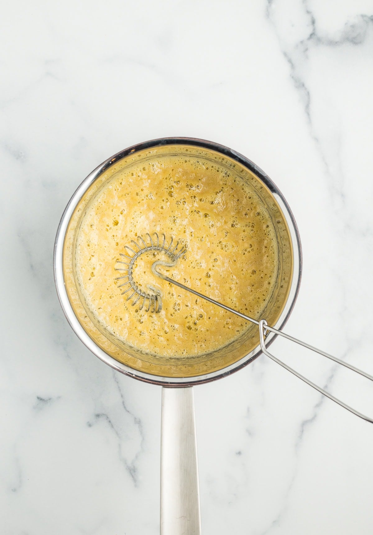 a whisk in a saucepan with butter.