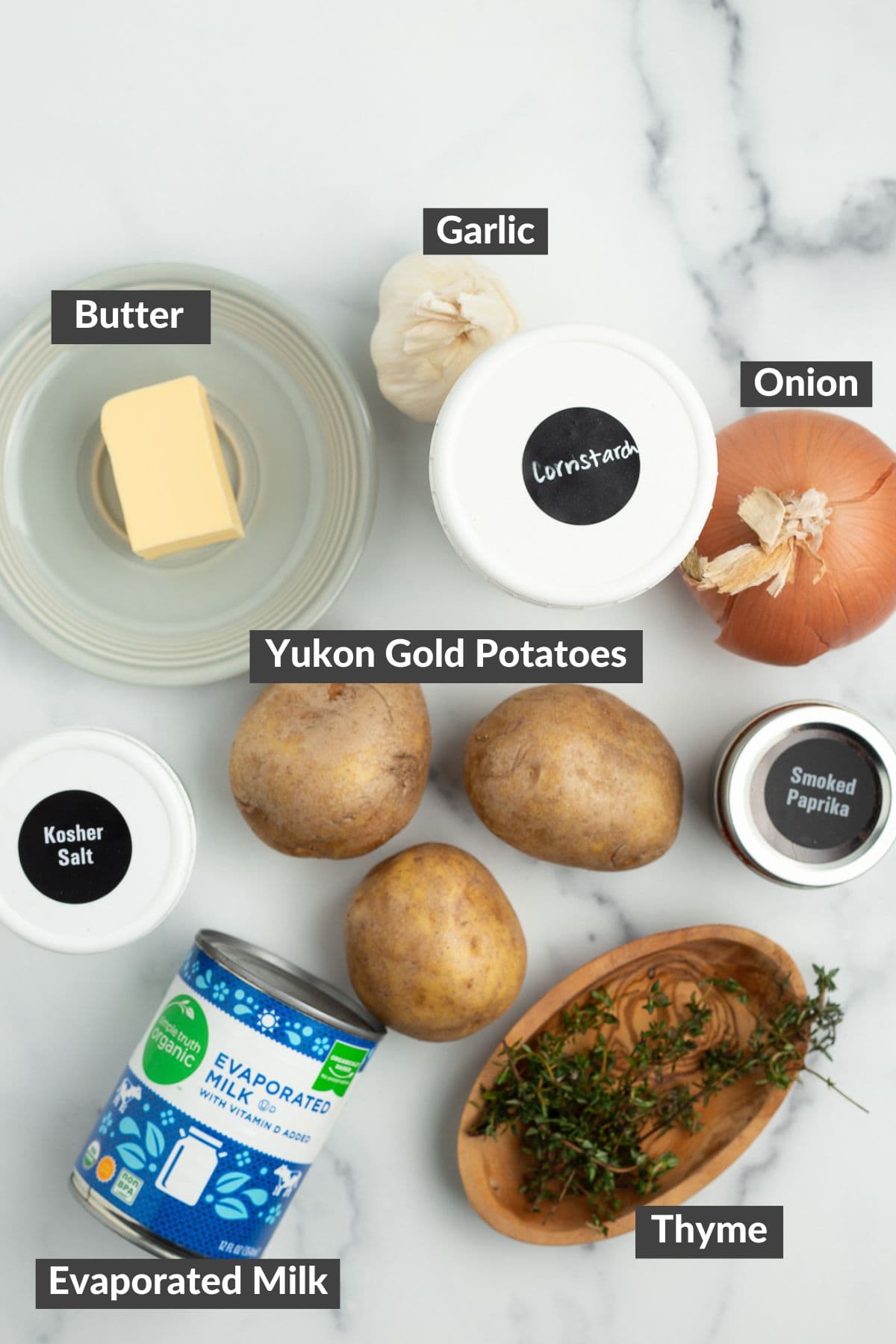 butter, onion, Yukon golds, and other ingredients on a marbled board.