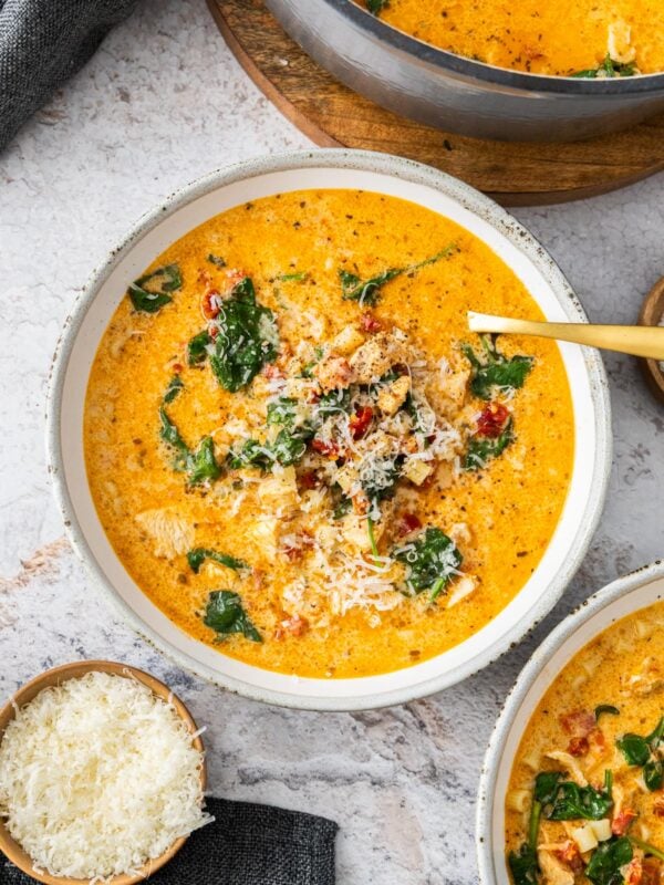 a grey and white bowl of Marry Me chicken soup topped with parmesan cheese.