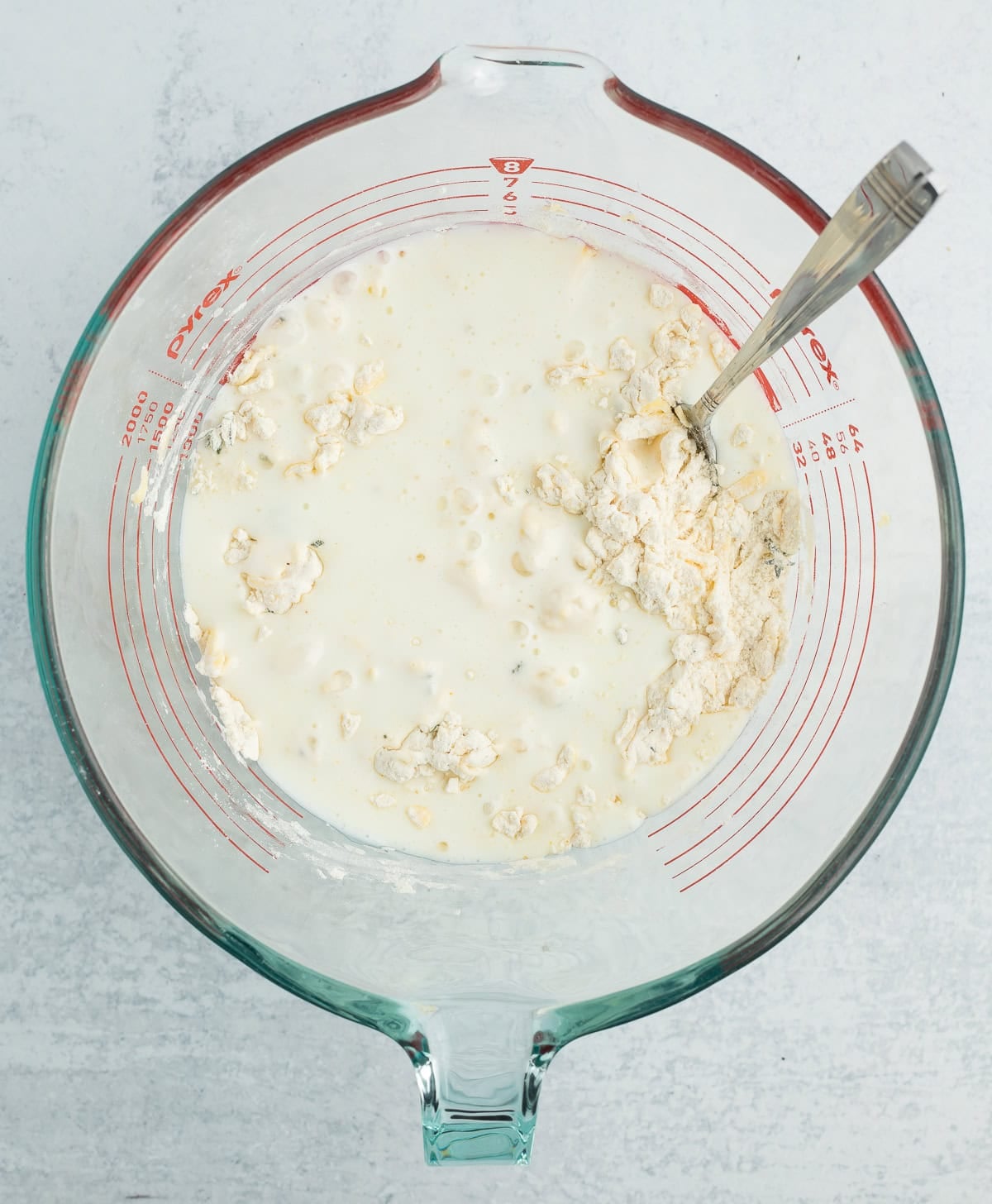 buttermilk in a mixing bowl with a spoon.
