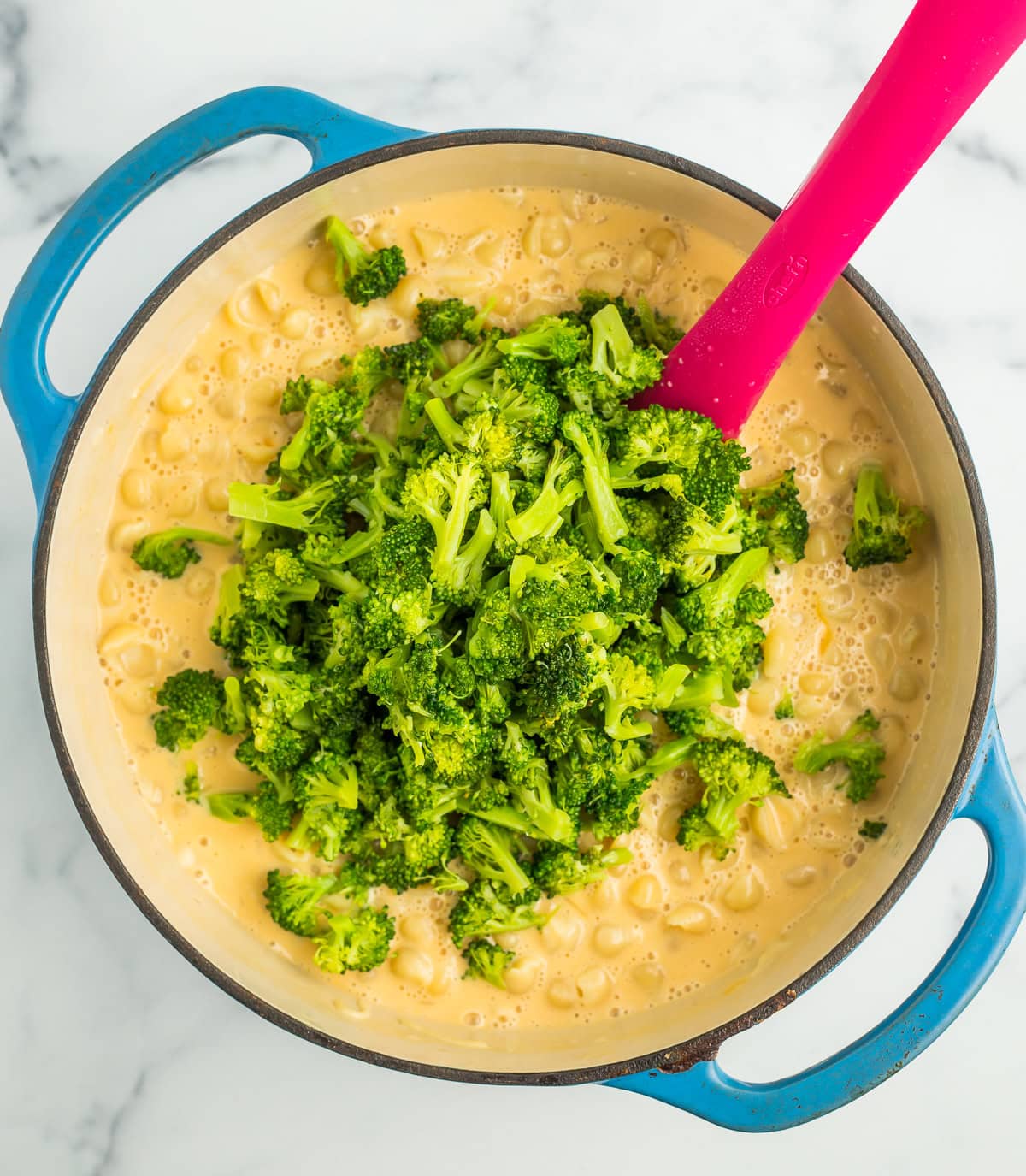 broccoli florets in a blue Dutch oven.