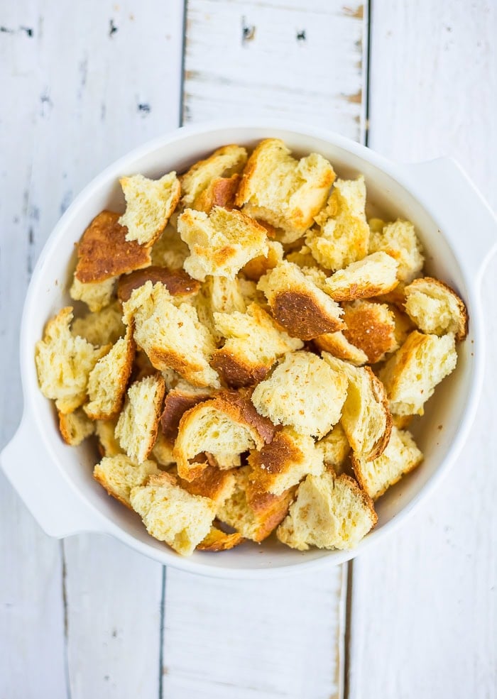 cubes of brioche in a white baking dish.