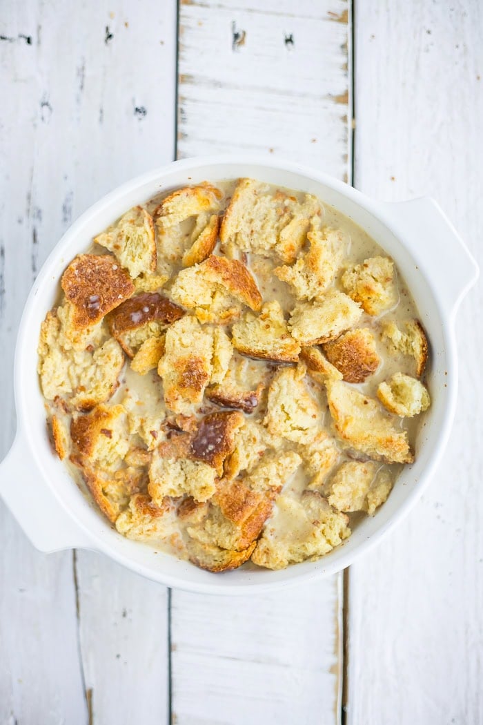 unbaked eggnog bread pudding in a white baking dish.