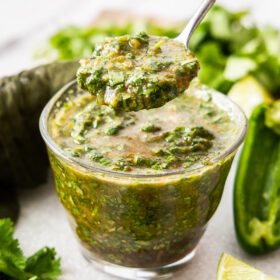 a spoonful of cilantro lime marinade hovering over a glass dish.