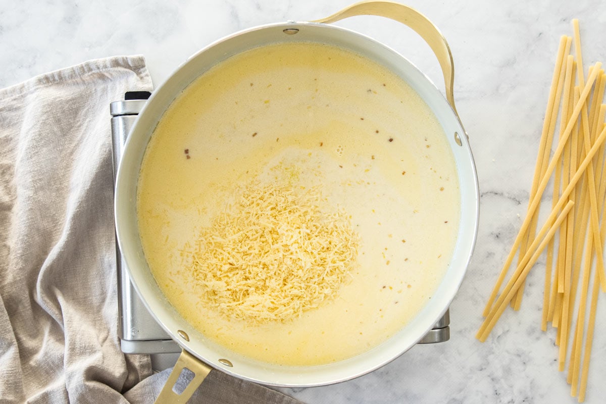 grated parmesan in a cream sauce in a skillet.