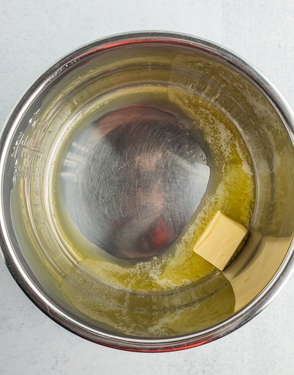 butter melting in a stainless pot.