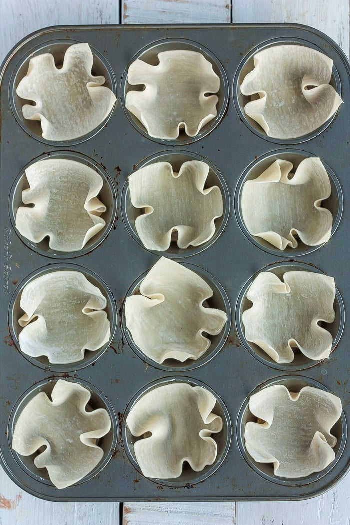 unbaked pastry cups in a muffin tin.