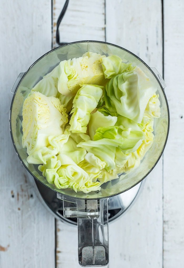 green cabbage in a food processor before chopping.