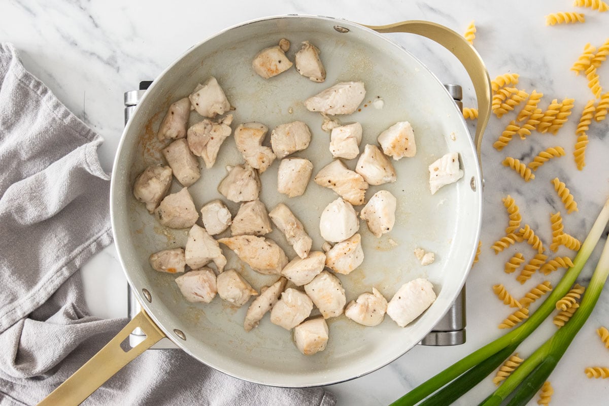 cubes of chicken in a skillet.