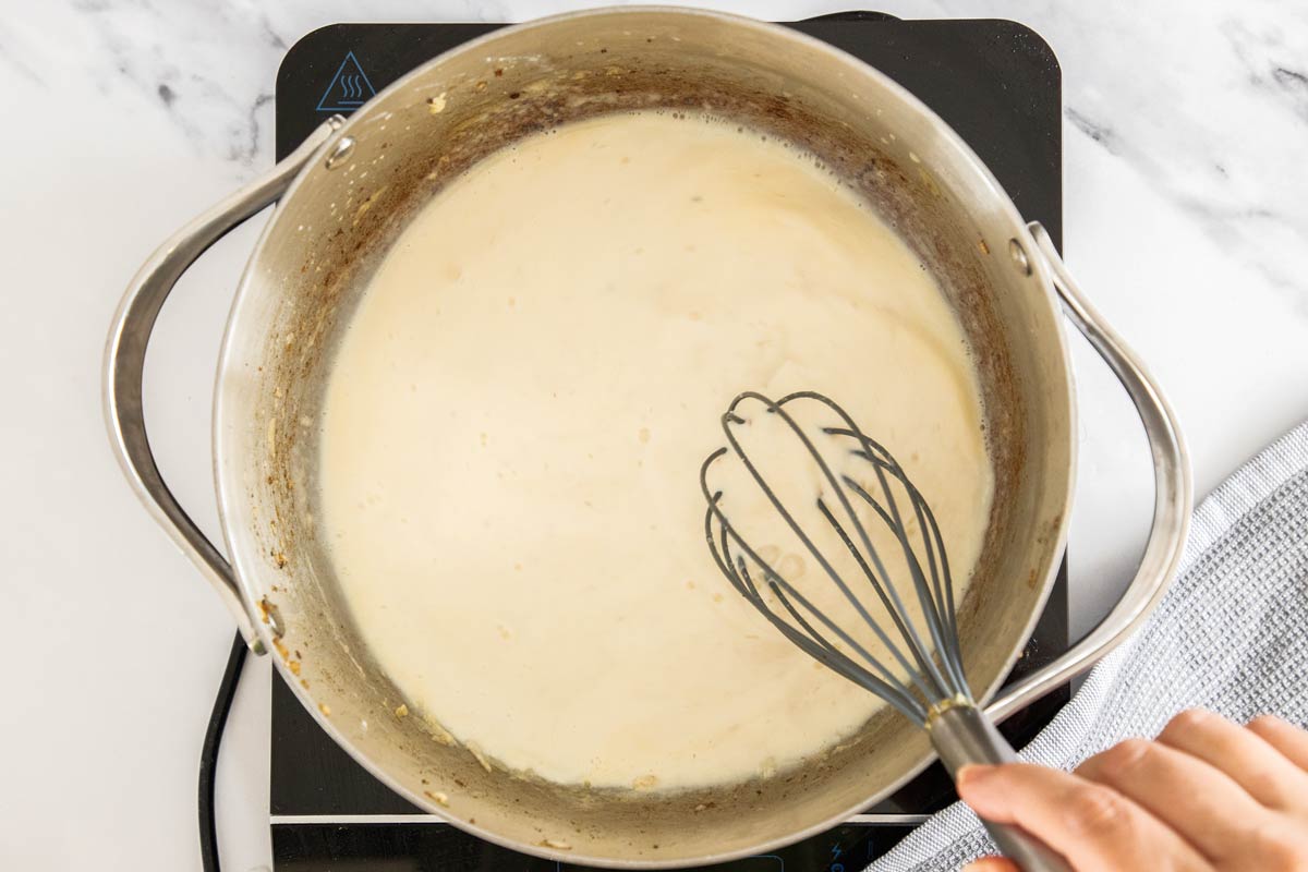 a cream sauce being made in a stockpot.