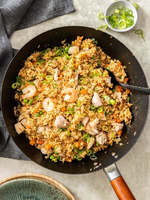 shrimp and chicken fried rice in a black wok.