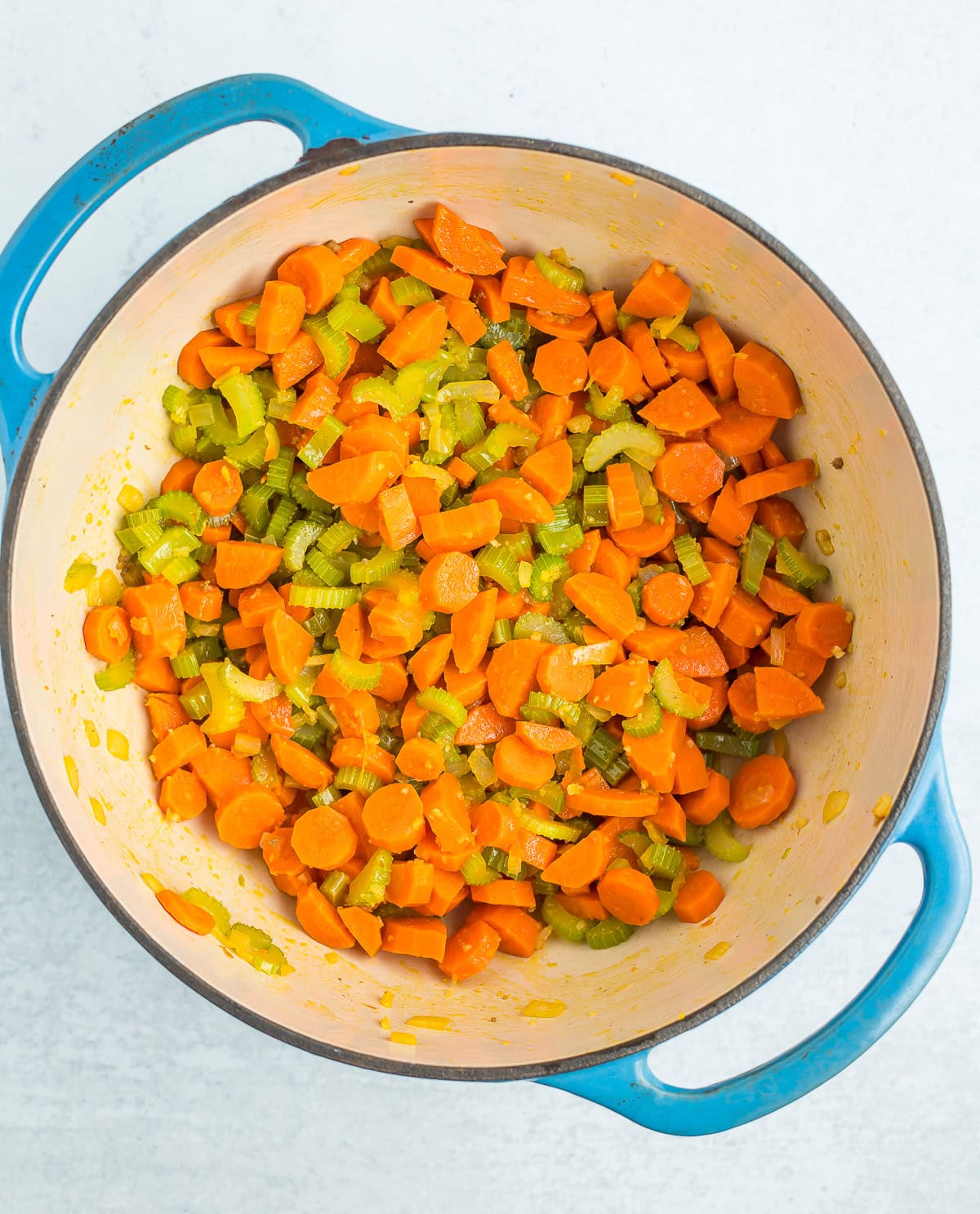 sauteed veggies in a blue Dutch oven.