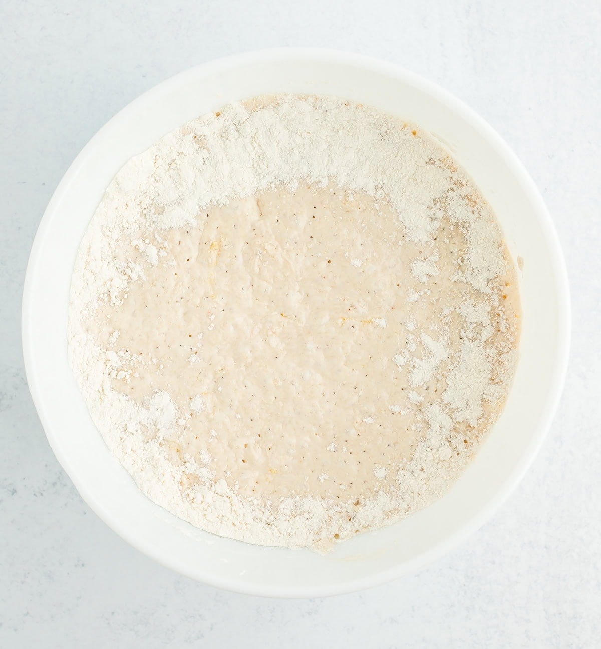 batter dusted with flour in a white mixing bowl.