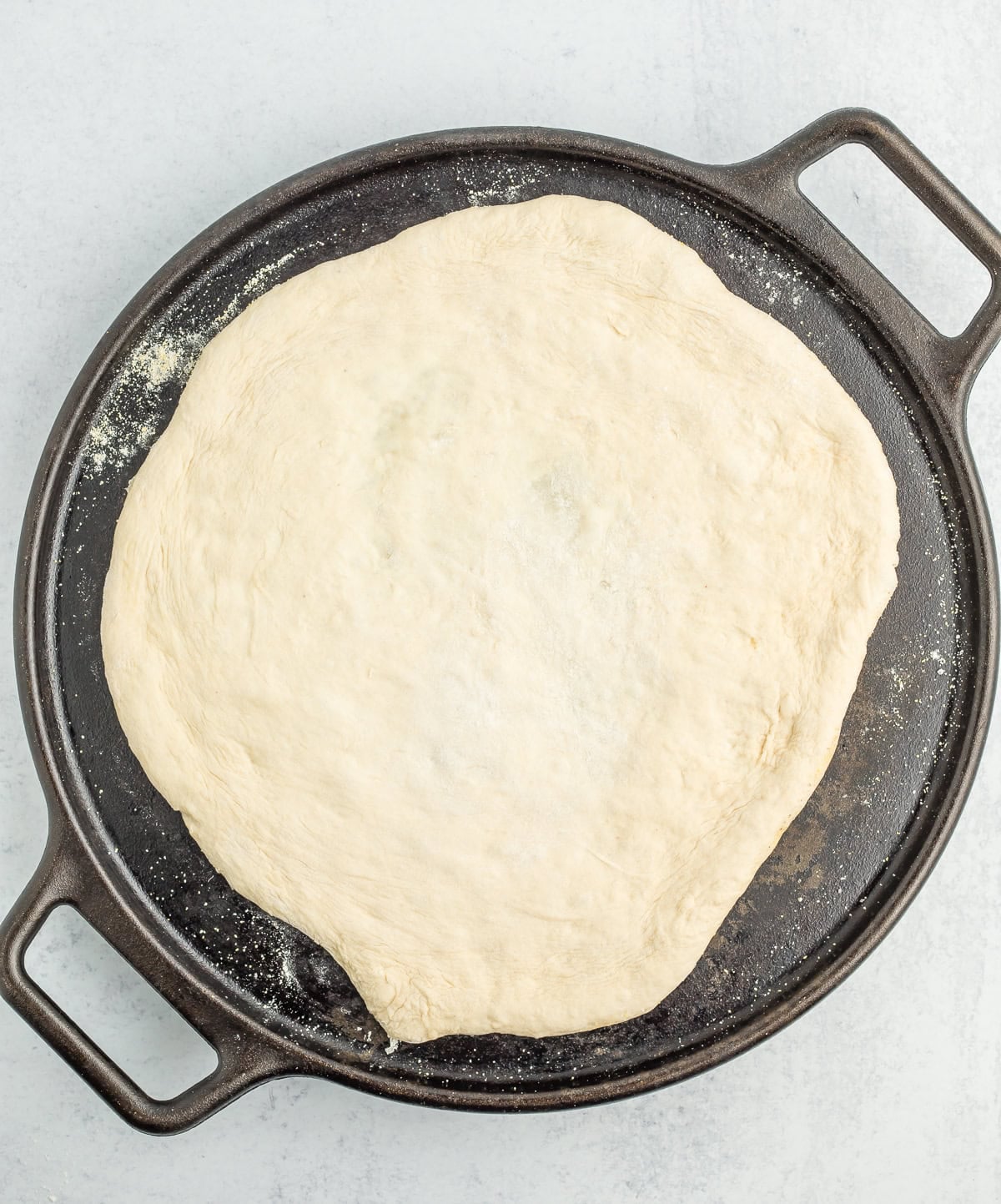 unbaked dough on a cast iron baking sheet.