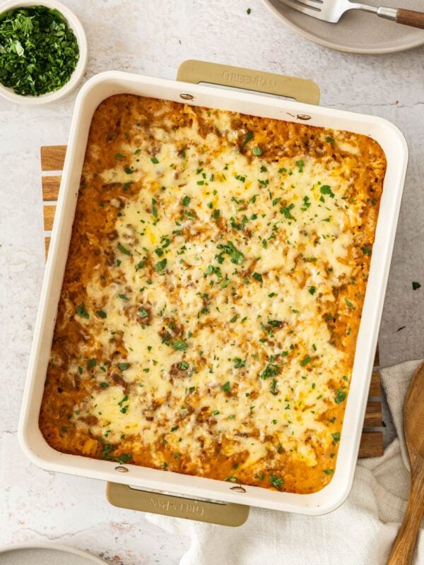 cheesy hamburger and rice casserole in a baking dish topped with chopped parsley.