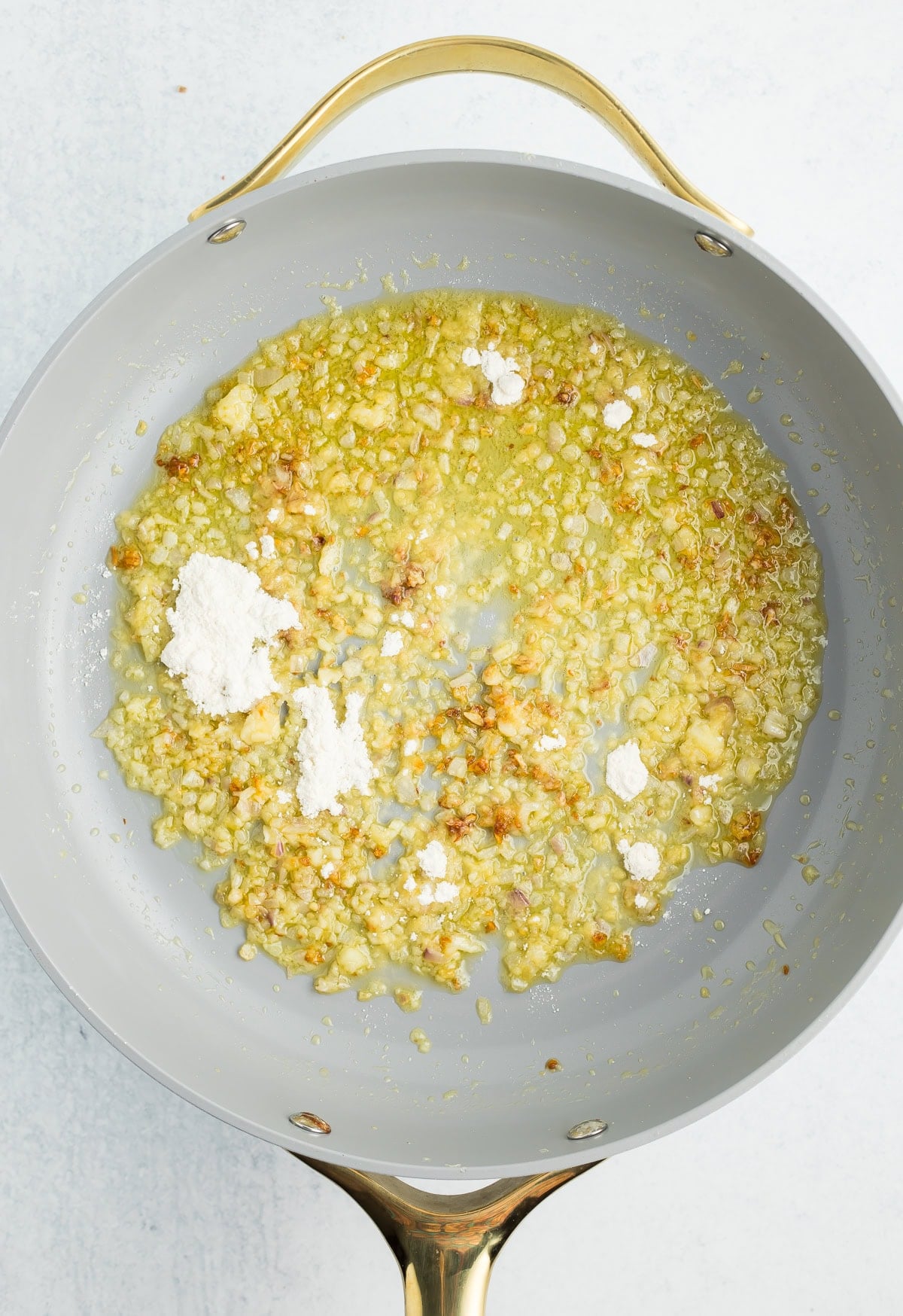 flour sprinkled into a pan of olive oil, butter, garlic, and shallots.