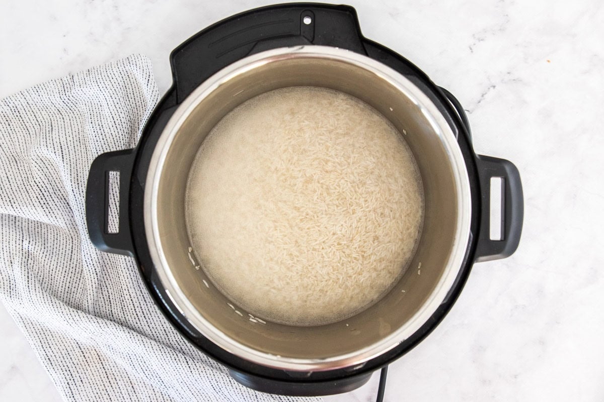 water and uncooked rice in a pressure cooker.