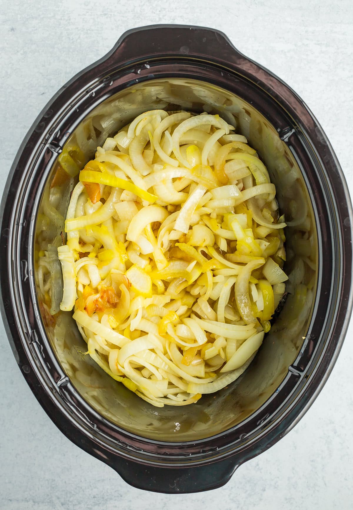 partially cooked onions in a crockpot.
