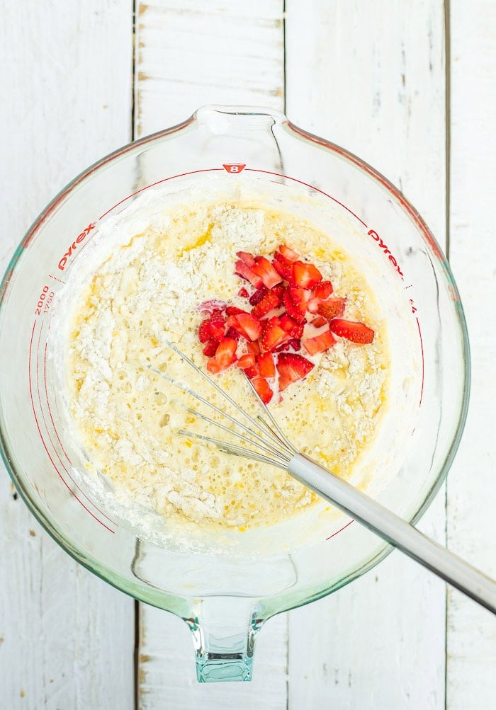 a whisk and ingredients in a glass bowl.