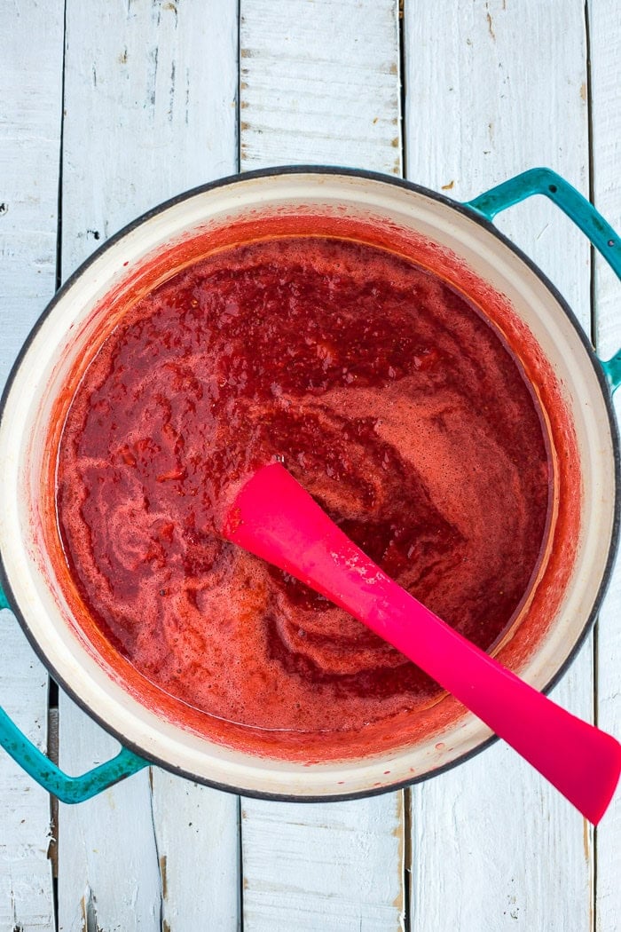 blended berry sauce in a blue Dutch oven.