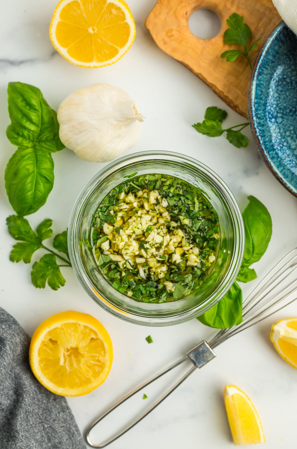 chopped garlic and herbs in a glass jar.