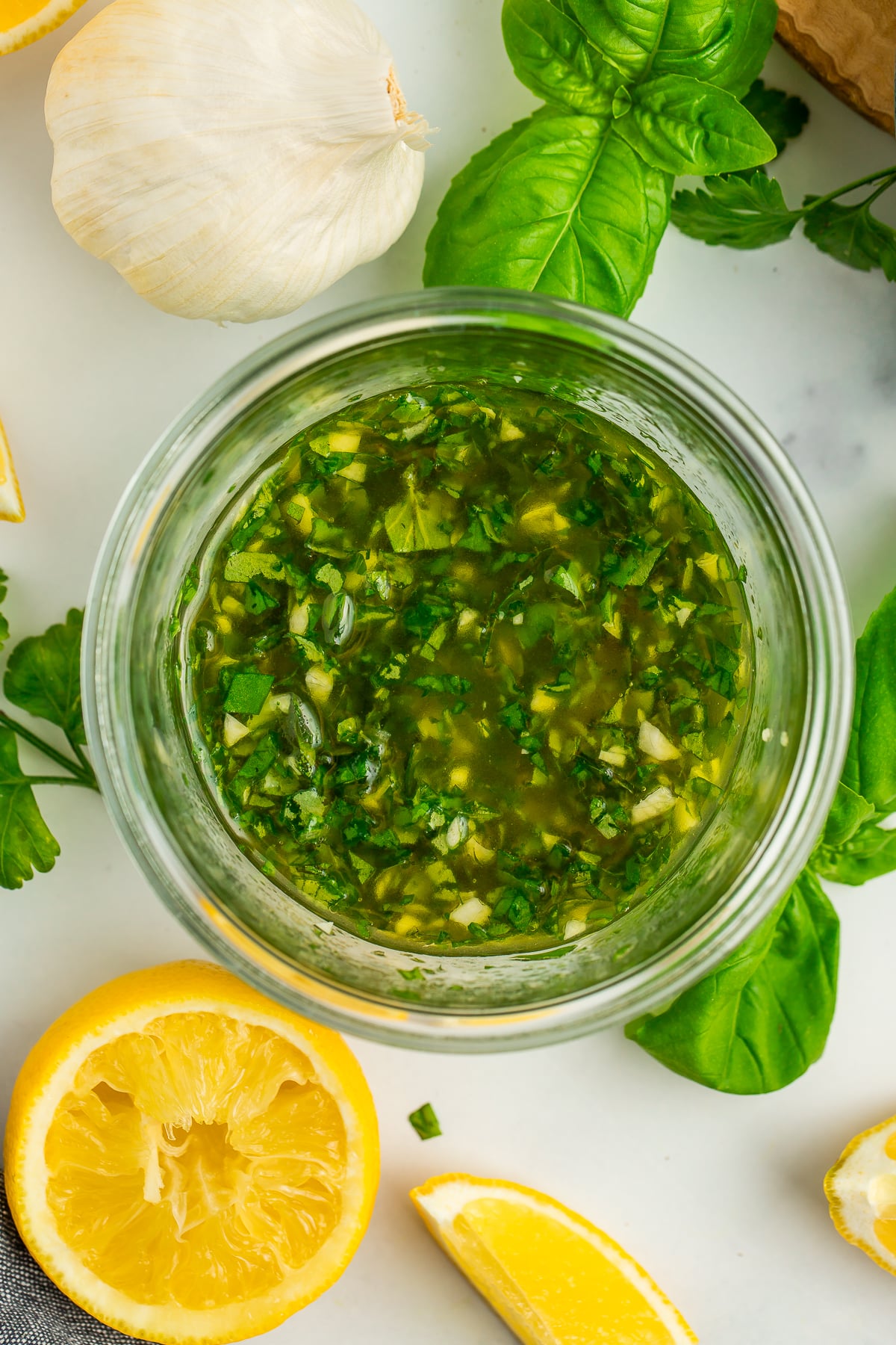 an overhead photo of an herb sauce in a glass jar.