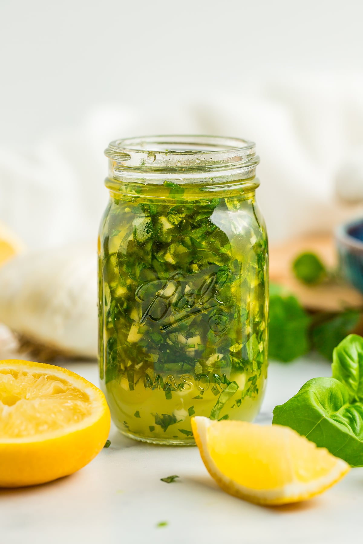 a side profile photo of a small glass jar of garlic and lemon chicken marinade.