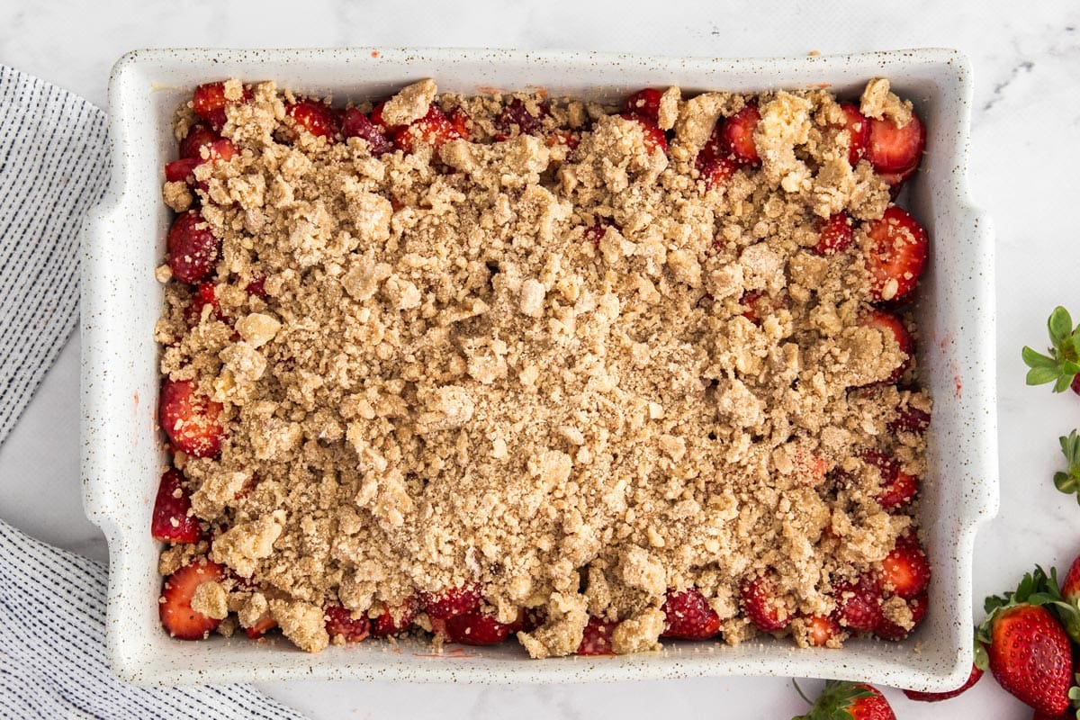 unbaked fruit crisp in a white baking dish.