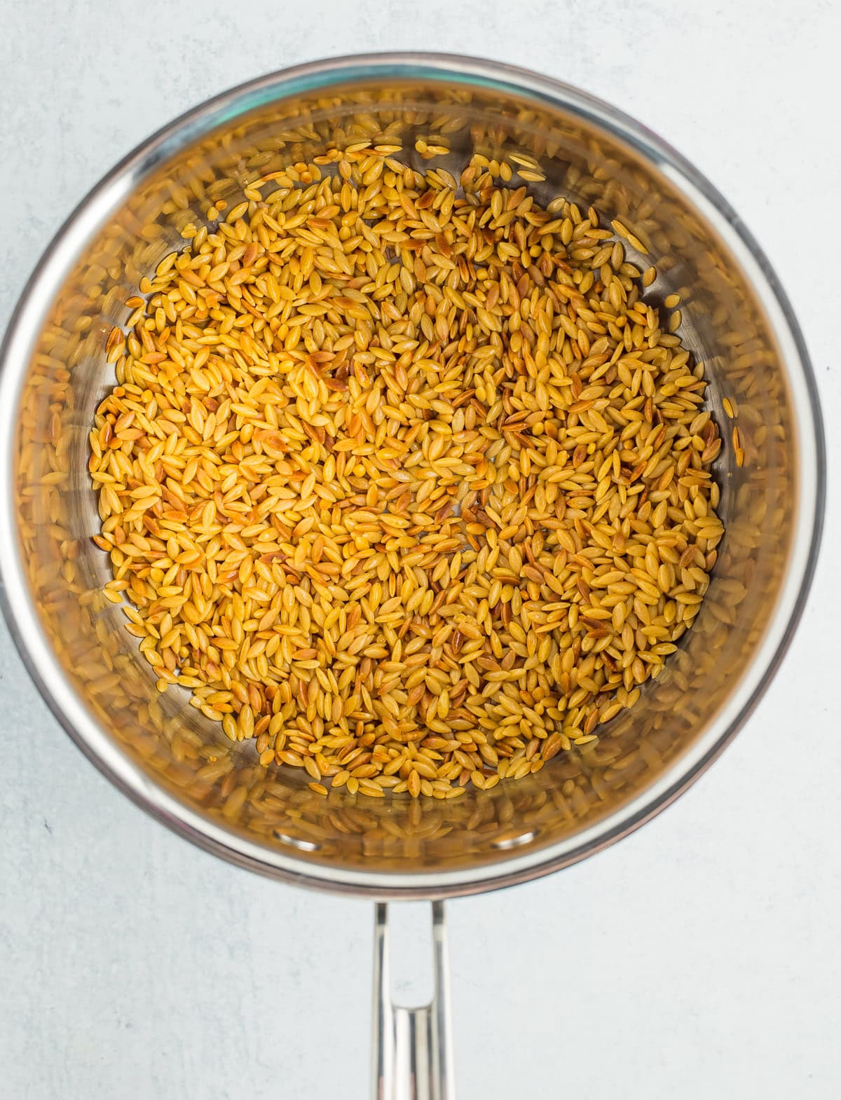 toasted orzo in a saucepan.