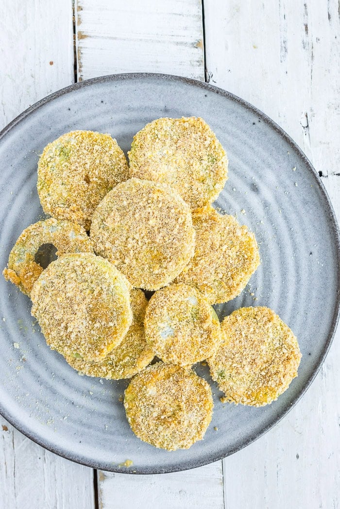 sliced of breaded tomato on a grey plate.