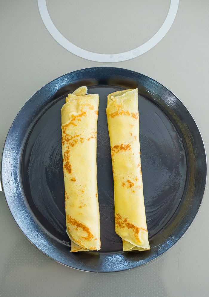 two crepes in an oiled pan.