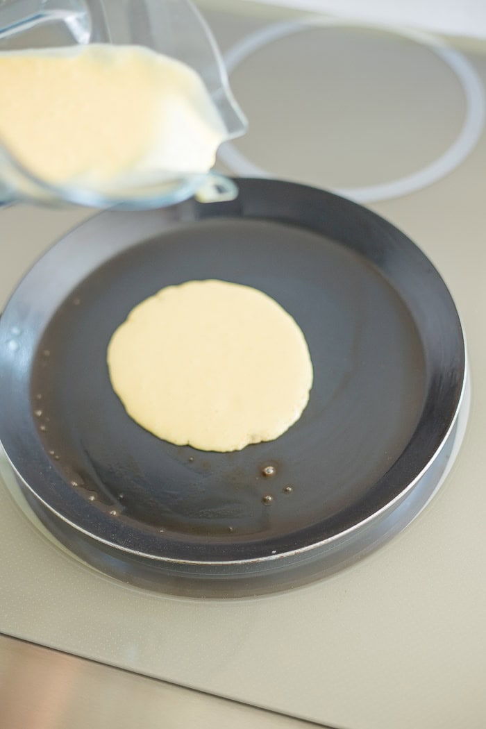 batter being poured into a pan on a stove.