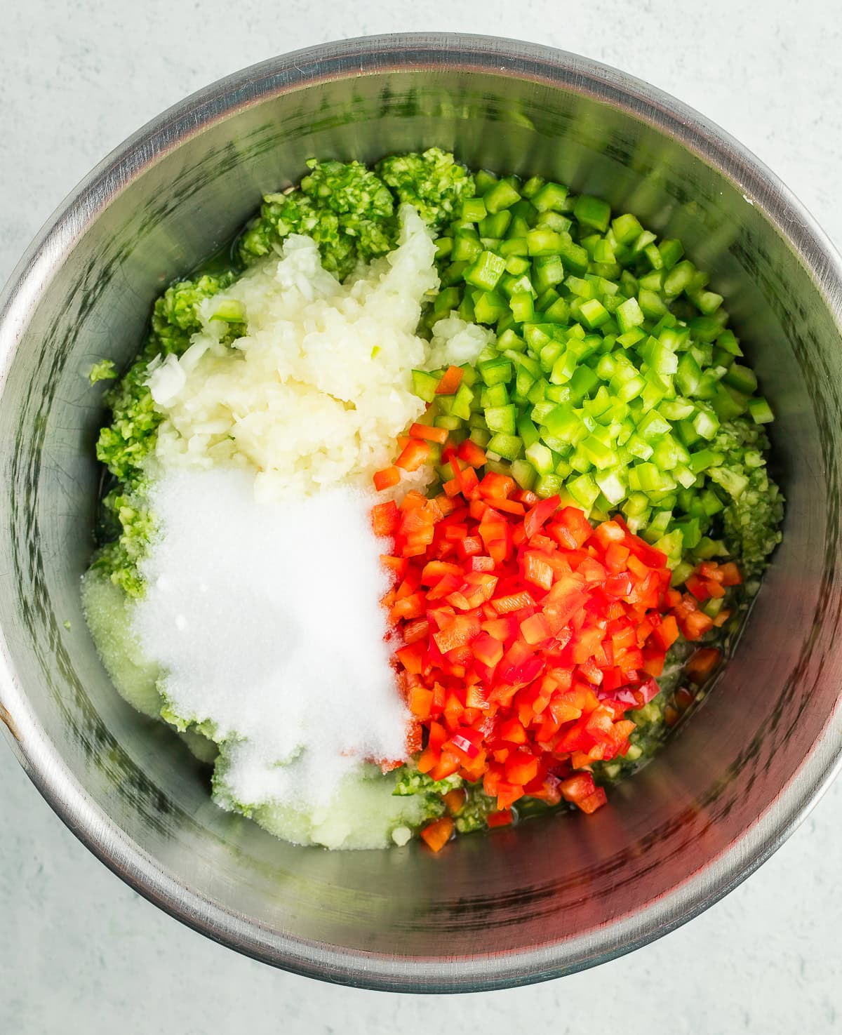 chopped cucumbers, onions, peppers, and salt in a large metal bowl
